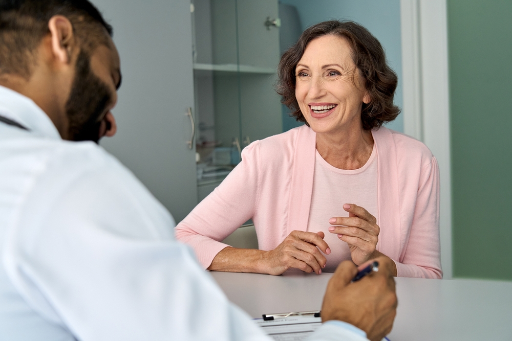 Paciente sorrindo conversando com médico.