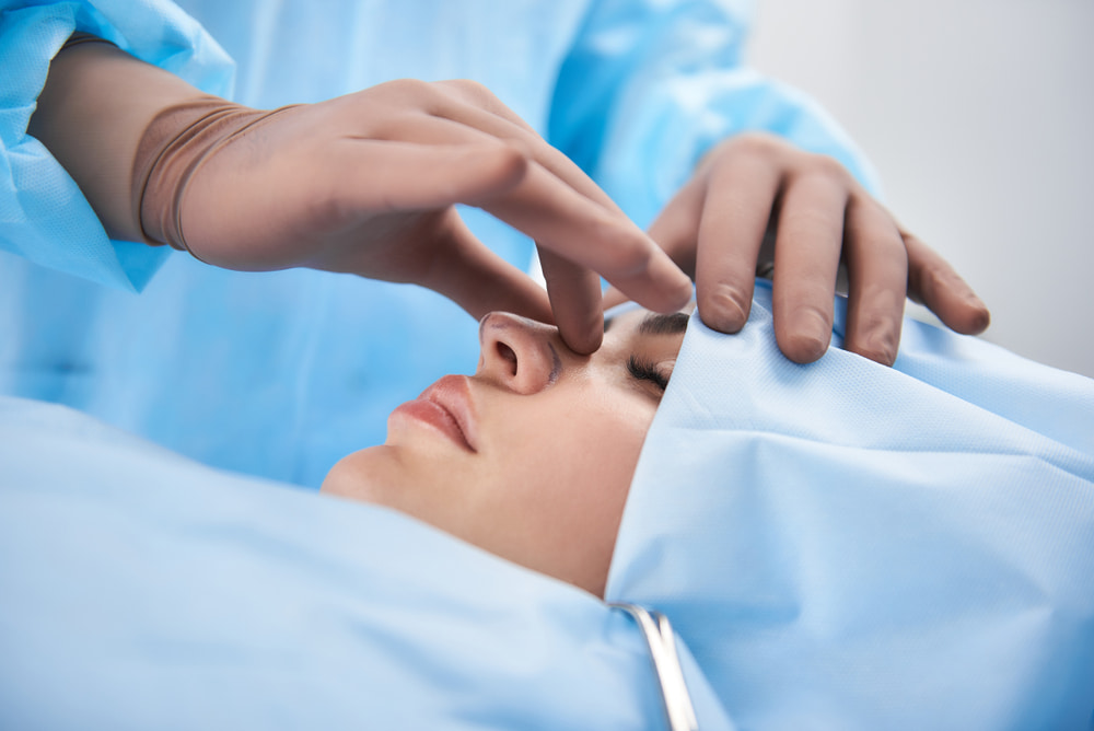 Profissional examinando rinoplastia estruturada de paciente.